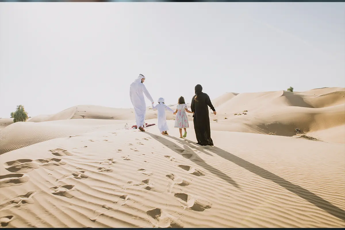 Family walking together across desert dunes